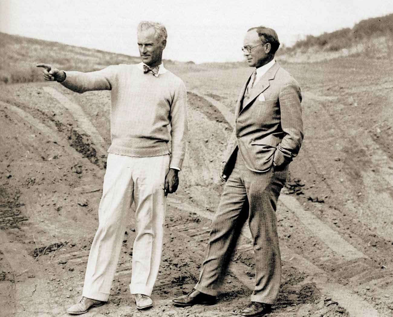 Historic photograph of two men surveying a course under construction